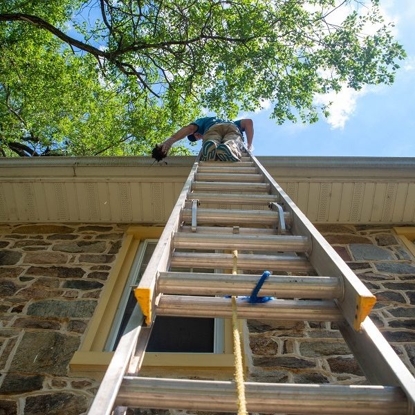 Man,On,A,Ladder,Cleans,The,Gutters,On,An,Old
